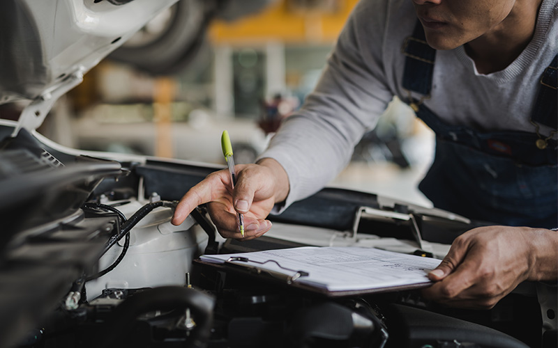 Technician performing a summer vehicle inspection at Prothro GMC.