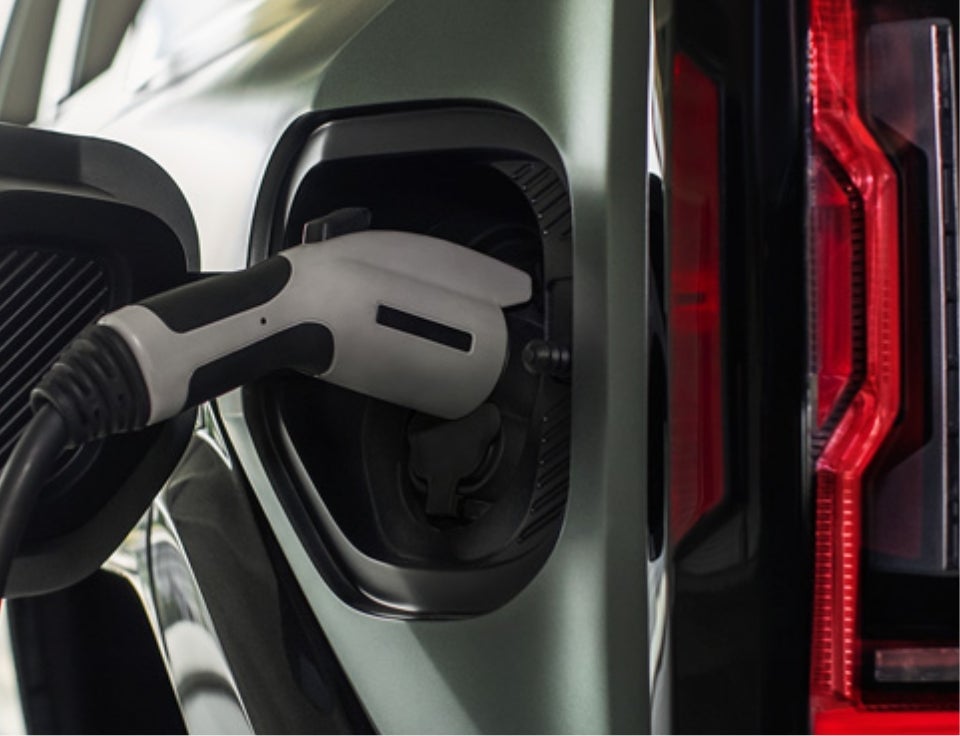 Close up of charging port with charger plugged in on a GMC Hummer EV SUV - Prothro GMC in Manning SC