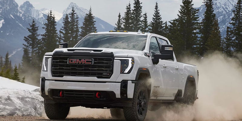 2026 GMC Sierra 2500 HD Pro driving through a snowy mountain landscape
