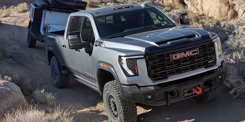 2026 GMC Sierra 2500 HD Pro driving on a rugged off-road trail